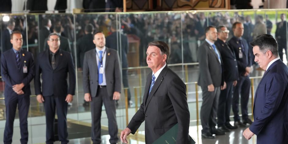 El mandatario Jair Bolsonaro camina hacia un atril, donde lo espera la prensa para ofrecer una conferencia.