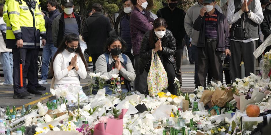 Ciudadanos y deudos oran frente a un memorial dedicado a las víctimas de la tragedia de Itaewon, ayer.