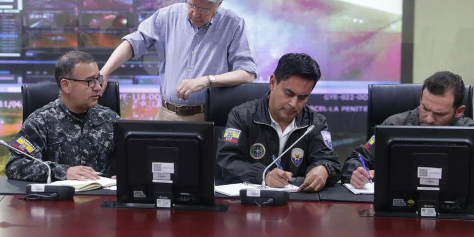 El presidente ecuatoriano, Guillermo Lasso (de pie), supervisa la respuesta policial ante los ataques, ayer.