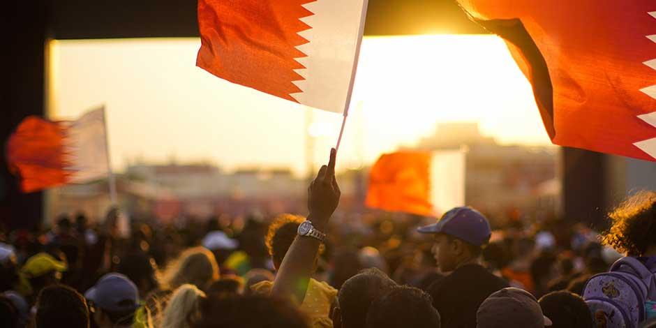 Personas, algunas con banderas de Qatar, llegan a la zona de aficionados antes de la ceremonia inaugural de la Copa del Mundo, en Doha, Qatar, el domingo 20 de noviembre de 2022