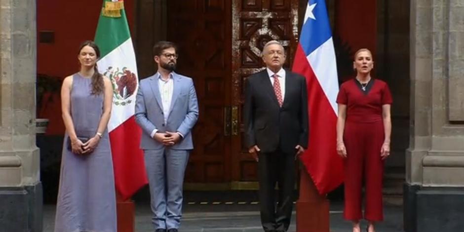 Los presidentes de Chile y México, Gabriel Boric y Andrés Manuel López Obrador, respectivamente realizan honores a la bandera acompañados de sus esposas