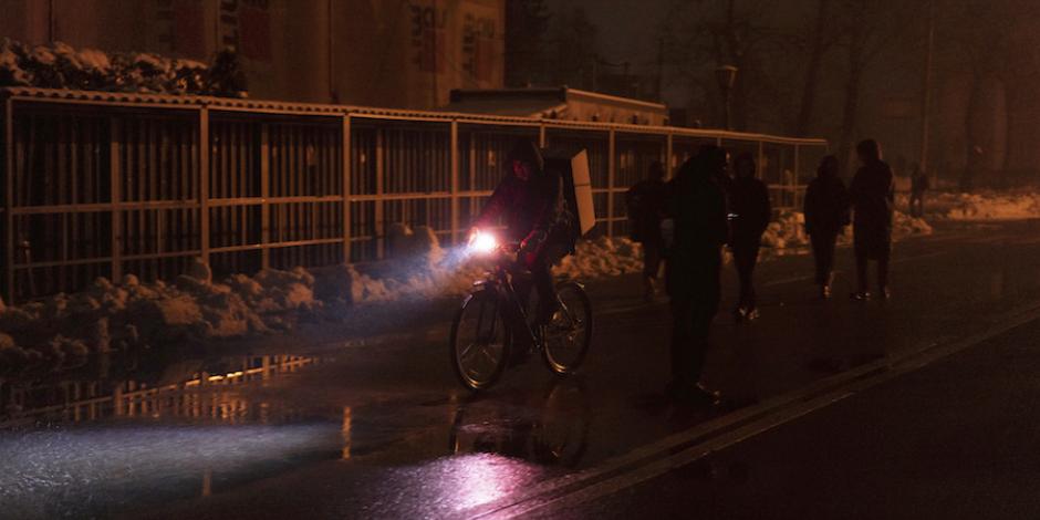 Ciudadanos se abren paso en calles de Kiev entre lámparas y las luces de bicis y autos.