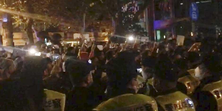 Imagen de un video obtenida por The Associated Press de la policía viendo a manifestantes en Shanghái el sábado, 26 de noviembre de 2022
