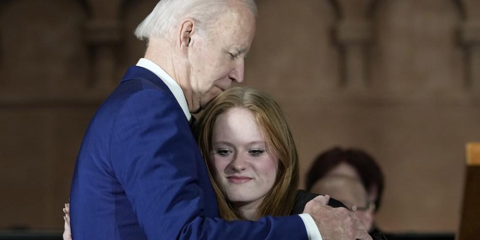 El presidente Joe Biden abraza a sobreviviente de la masacre en una ceremonia, ayer.