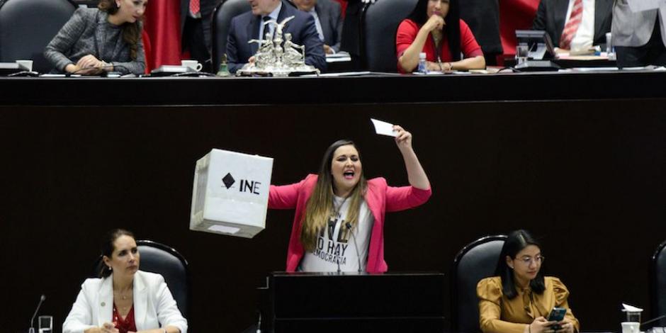 La diputada priista Cynthia López Castro muestra una urna en la tribuna, ayer, durante el debate.