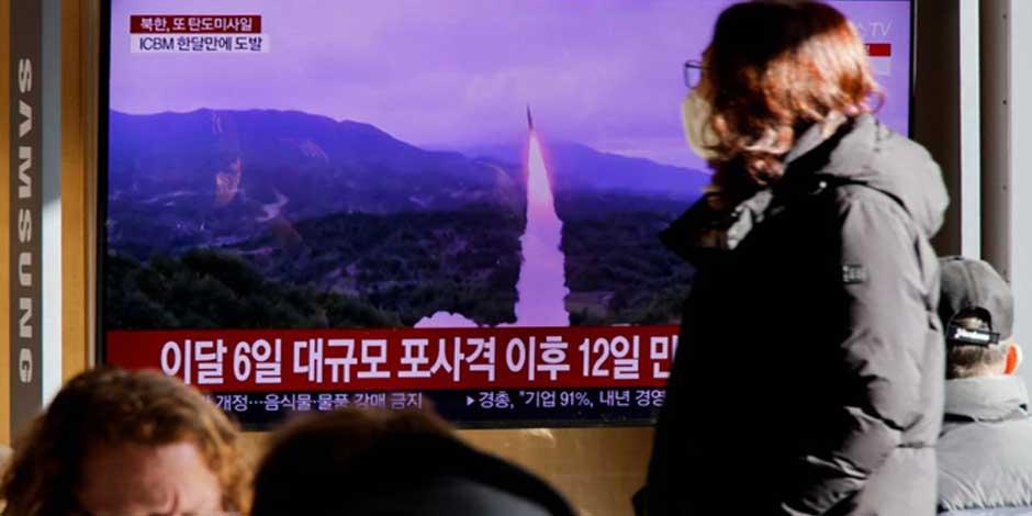 Una mujer pasa frente a un televisor que transmite un informe de noticias sobre Corea del Norte disparando un misil balístico frente a su costa este, en Seúl, Corea del Sur, el 18 de diciembre de 2022