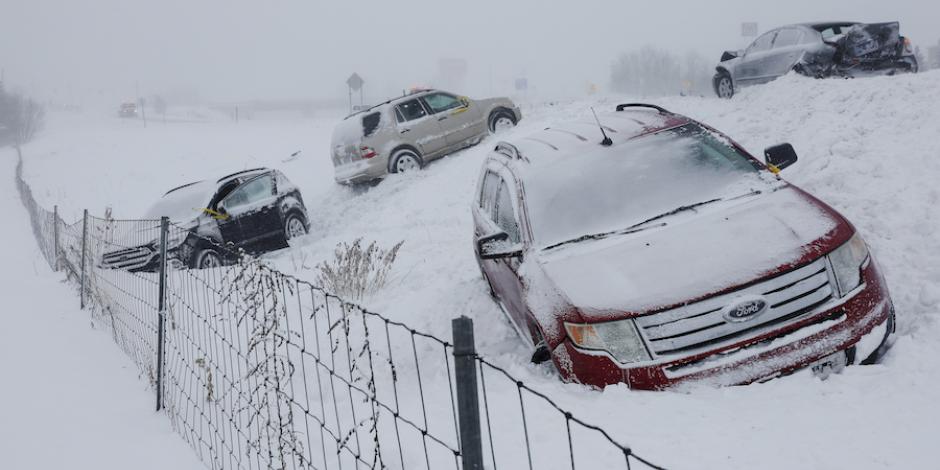 Vehículos quedaron varados por la nieve en una carretera en Michigan, ayer.