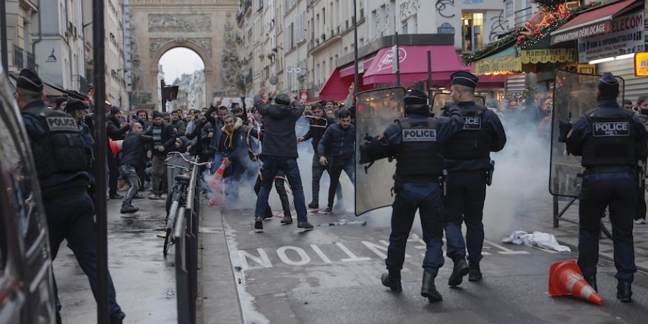 Policías repliegan a manifestantes kurdos en calles de París, ayer.