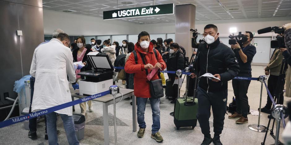 Personal revisa la documentación Covid de viajeros procedentes de China, en Milán, ayer.