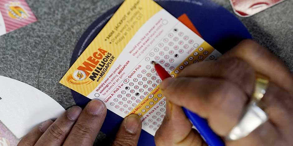 Un cliente llegan un boleto de lotería Mega Millions en una tienda de conveniencia en Northbrook, Illinois, el 6 de enero de 2021.