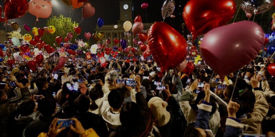 Las personas sueltan globos mientras se reúnen para celebrar la víspera de Año Nuevo.