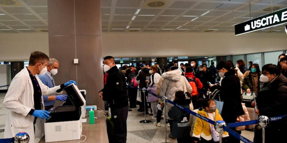 Pasajeros que llegan de China esperan en fila para la aplicación o revisión de las pruebas Covid, ayer, en un aeropuerto de Italia.