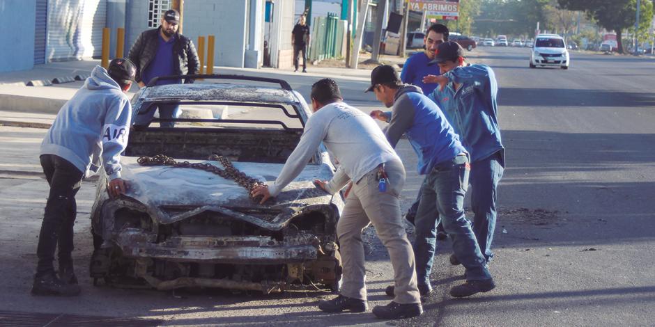 Retiro de vehículos quemados en las vialidades de Culiacán, Sinaloa, ayer.