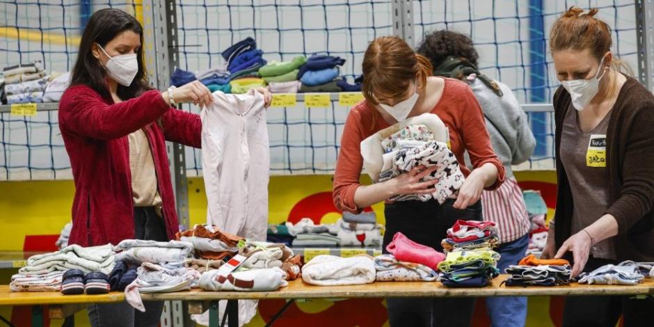 Voluntarios organizan ropa donada para personas ucranianas que viven asediadas por la guerra