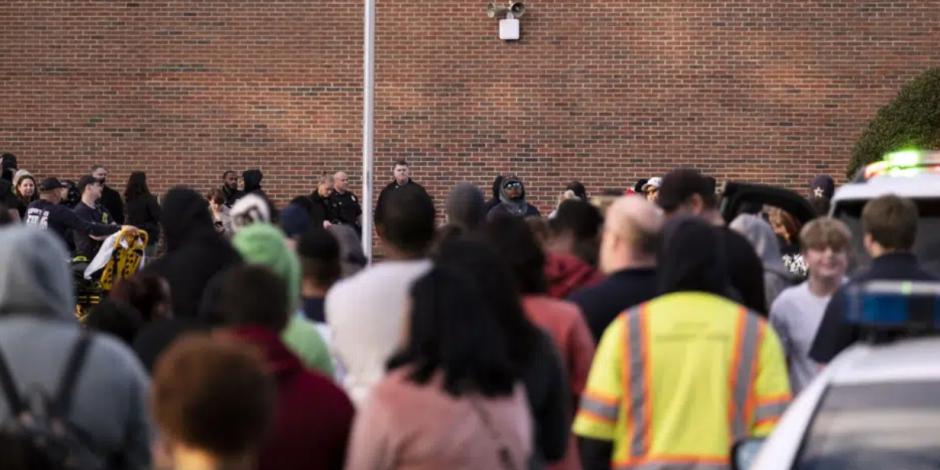 Estudiantes y agentes de la policía se reúnen afuera de la Escuela Primaria Richneck, luego de un tiroteo el viernes 6 de enero de 2023, en Newport News, Virginia.