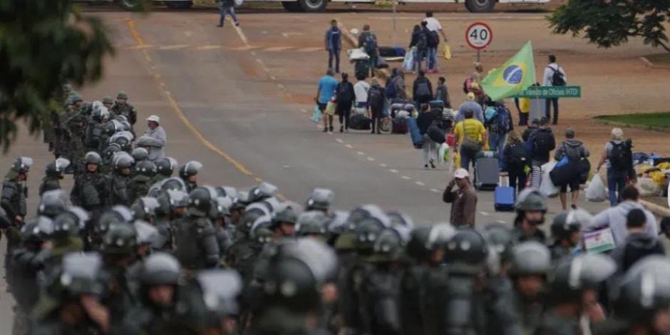 Policías toman posiciones mientras los partidarios del expresidente de Brasil, Jair Bolsonaro, abandonan un campamento frente a la sede del Ejército en Brasil, el lunes 9 de enero de 2023.