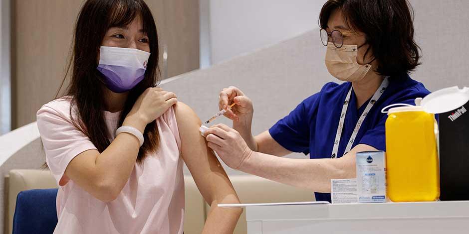 Una mujer de China continental recibe una dosis de la vacuna contra la enfermedad del coronavirus bivalente (COVID-19) de BioNTech en una clínica privada en Hong Kong