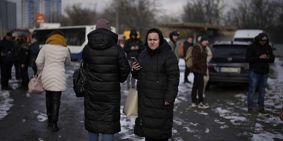 Gente esperando en una calle cortada por la policía tras un ataque de cohete en Kiev, Ucrania, el jueves 26 de enero de 2023.