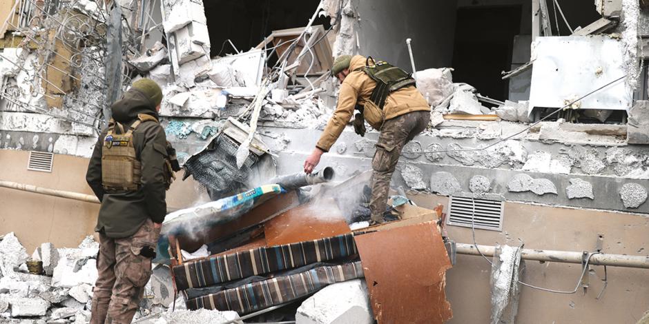 Elementos de emergencias en Ucrania inspeccionan un inmueble bombardeado en Jerson, ayer.