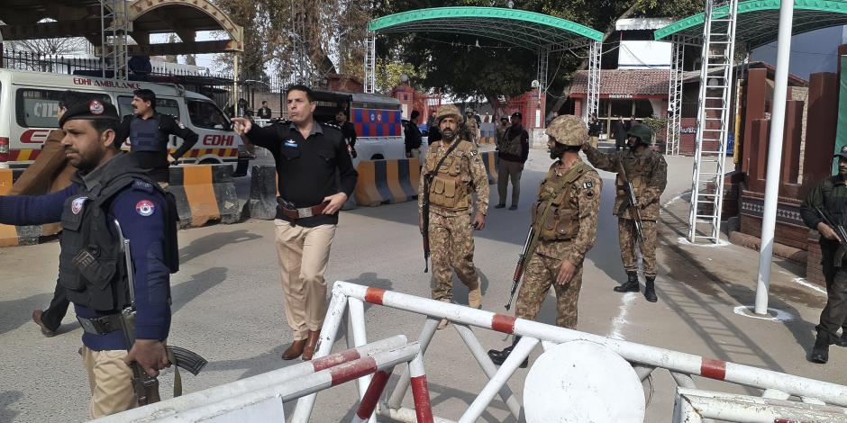 Soldados y policías despejan el acceso para ambulancias al lugar donde explotó una bomba, en una entrada a oficinas policiales en Peshawar, Pakistán, el lunes 30 de enero de 2023