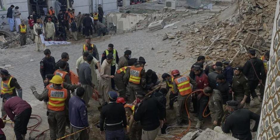 Agentes de seguridad y rescatistas buscan cuerpos en el lugar de un ataque suicida en Peshawar, Pakistán.
