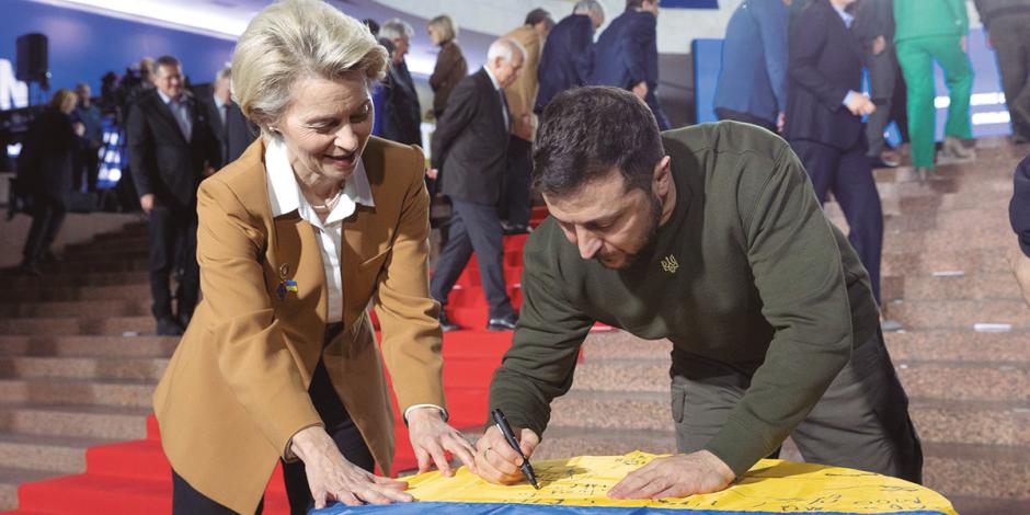 Zelenski agradece respaldo de la UE al firmar una bandera ucraniana para sus aliados europeos.