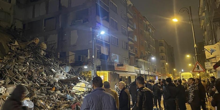 Afectados se reúnen frente a un edificio colapsado por si escuchan a posibles víctimas.