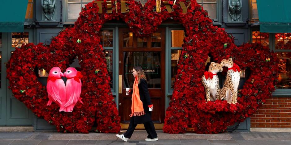 Mujer camina frente a un adorno de San Valentín, en Londres.