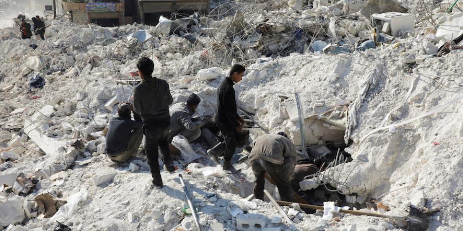 Habitantes buscan sobrevivientes bajo los escombros de uno de  los edificios dañados en la ciudad rebelde de Harem, Siria, ayer.