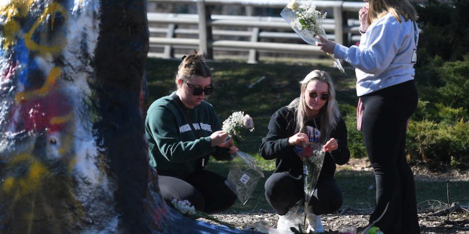 Estudiantes colocan flores en el campus de la Universidad Estatal de Michigan después del tiroteo, ayer.