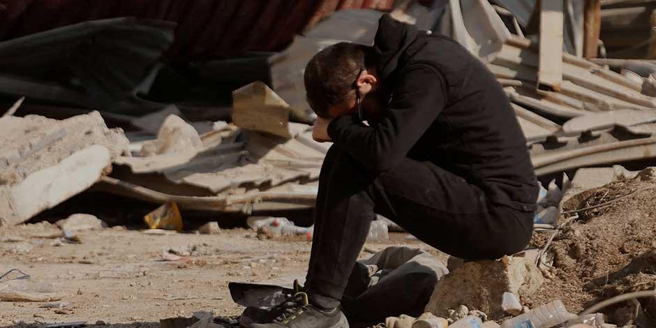 Un hombre reacciona mientras la gente busca pertenencias personales entre los escombros de los bloques de apartamentos derrumbados, después de un terremoto mortal, en Kahramanmaras, Turquía, el 18 de febrero de 2023