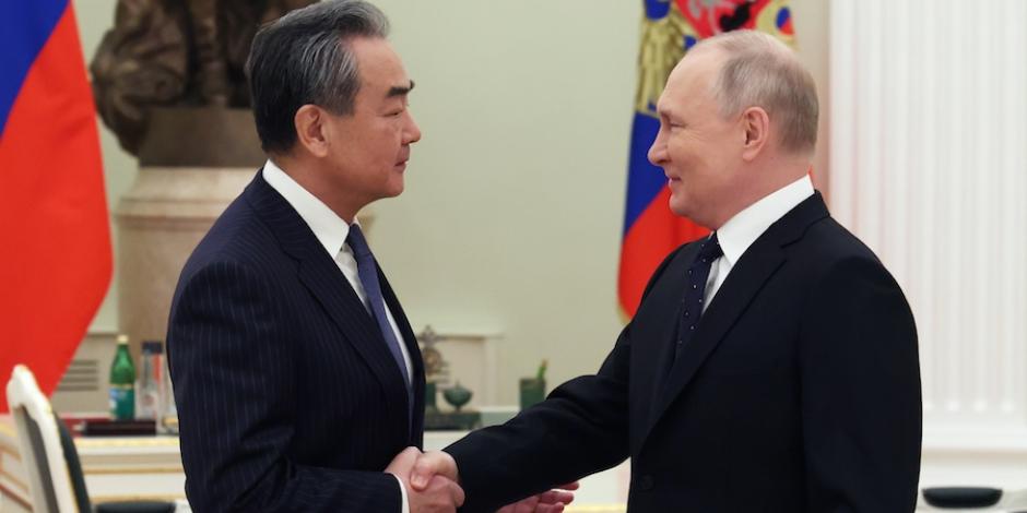 El ministro de Exteriores chino (izq.), Wang Yi, saluda al presidente de Rusia, Vladimir Putin, ayer.