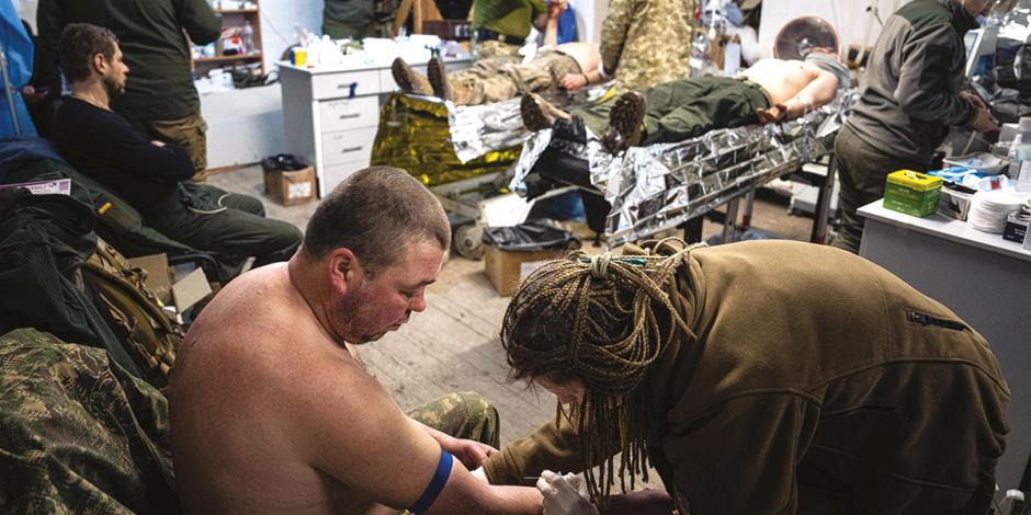 Médicos ucranianos atienden a soldados y combatientes heridos en espacios que han improvisado, cerca del frente de batalla en Bajmut, ayer.