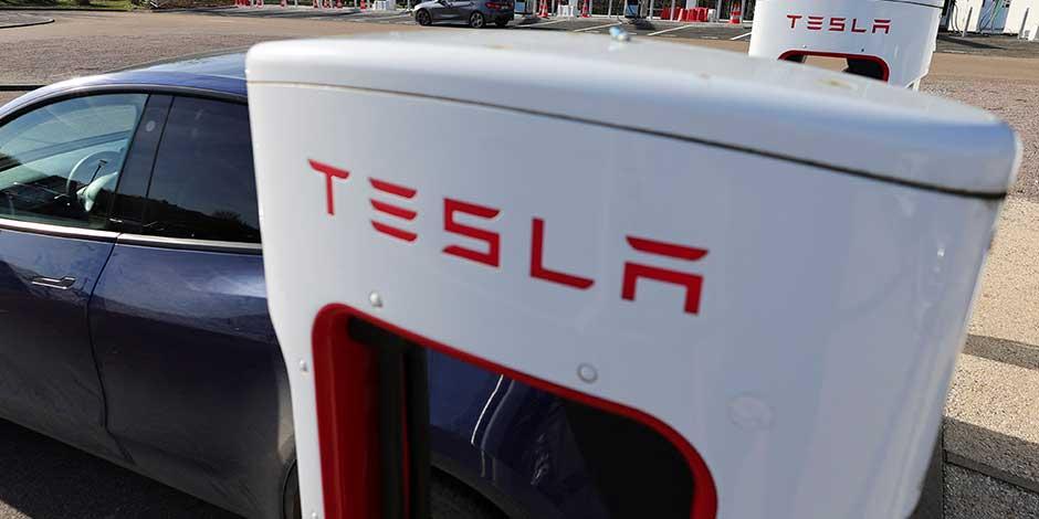 Un conductor recarga la batería de su automóvil Tesla, en una estación de carga Tesla Super, en una gasolinera en la autopista en Chateauvillain, Francia