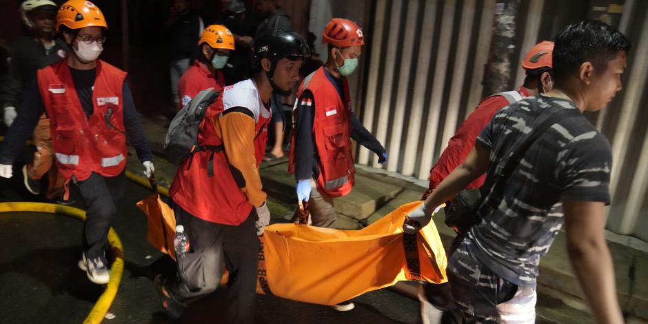 Rescatistas llevan el cuerpo de una víctima de un incendio en Yakarta, Indonesia, viernes 3 de marzo de 2023.