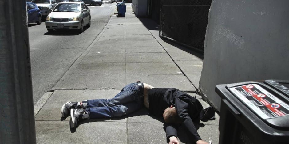 En 2021, el consumo de fentanilo en EU llegó a causar más de 107 mil muertes; en la imagen, un hombre yace junto a un contenedor de basura en San Francisco.