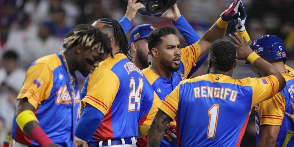 Anthony Santander (centro) es felicitado por sus compañeros de Venezuela tras batear un jonrón ante República Dominicana, en un duelo del Clásico Mundial de Beisbol