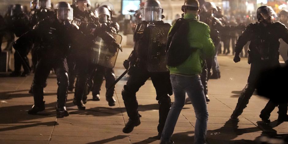 Policías con escudos enfrentan a manifestantes en calles de París, ayer.