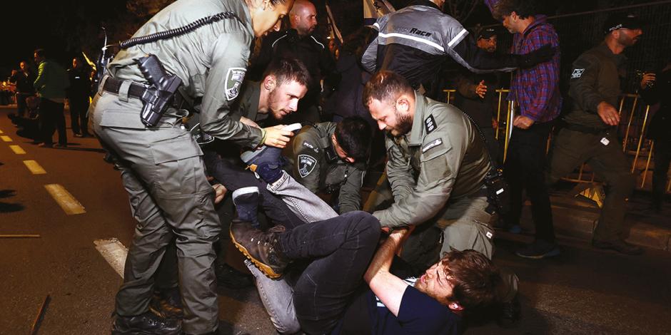 Oficiales someten a un manifestante durante protestas contra la reforma judicial de Bibi.