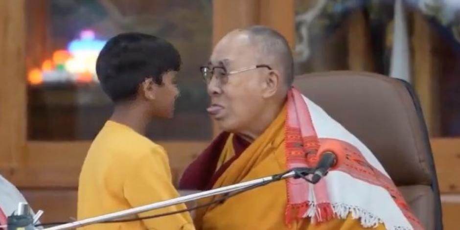 Dalai Lama besa a un niño en la boca.
