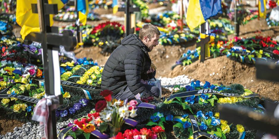 Un residente ucraniano visita las tumbas de las víctimas locales que ha dejado esta guerra, ayer.