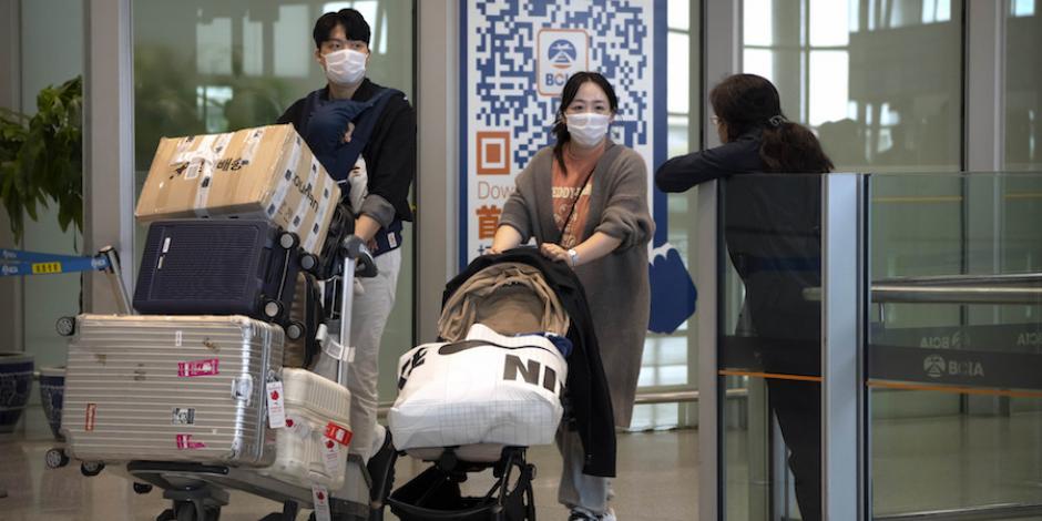 Viajeros mantienen el uso de mascarillas en aeropuertos como en China, ayer.