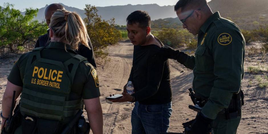 Elementos de la policía de Estados Unidos detienen a un hombre que presumiblemente intentó cruzar la frontera entre México y este país de forma ilegal.