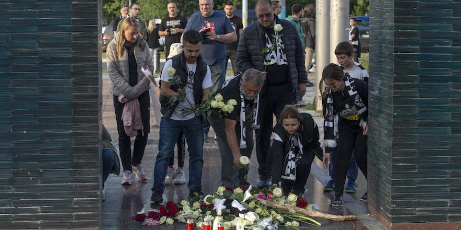 Pobladores colocan flores en homenaje a las víctimas de un tiroteo escolar en Belgrado un día antes.