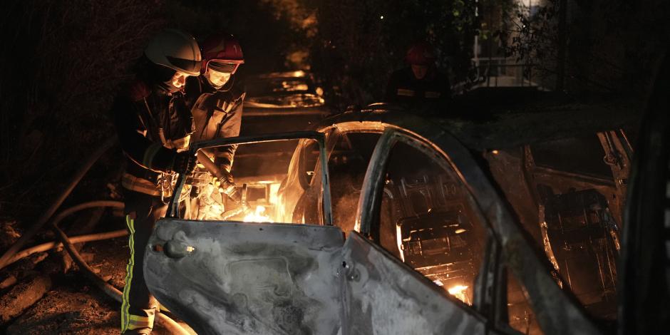 Socorristas tratan de apagar un auto que se incendió por la caída de escombros tras un ataque aéreo ruso en el distrito de Pecherskyi, en Kiev, Ucrania, el martes 30 de mayo de 2023.