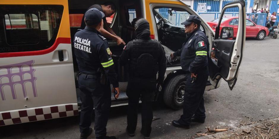 Policías detienen a un hombre que llevó a 10 personas a votar en Cuautitlán Izcalli, ayer.