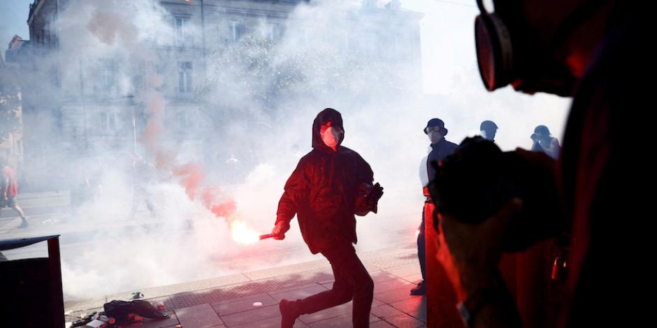 Un manifestante sostiene una bengala roja durante los enfrentamientos en Nantes, ayer.