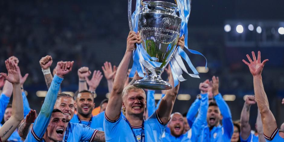 Erling Haaland festeja con el resto de los jugadores del Manchester City mientras carga el trofeo de la Champions League.