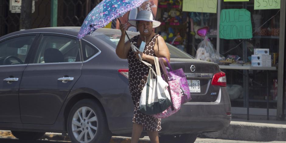 Una mujer se refugia de los rayos del sol en calles de la ciudad de Monterrey, ayer.