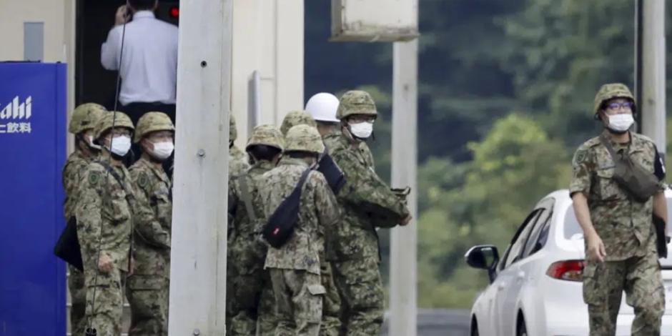 Miembros de la Fuerza de Autodefensa de Japón se reúnen cerca de una instalación en un campo de tiro de la base, luego de un tiroteo mortal en Gifu, en el centro de Japón, el miércoles 14 de junio de 2023.